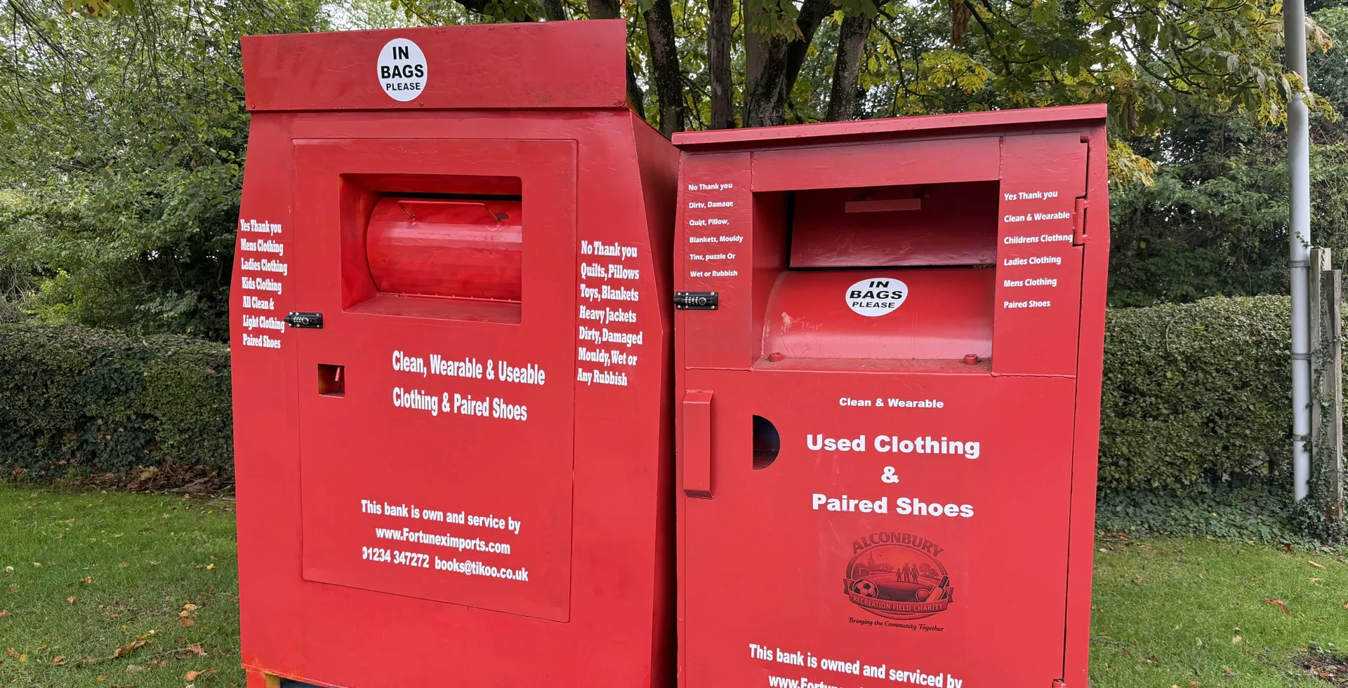 Red textile recycling bins for used clothing and paired shoes